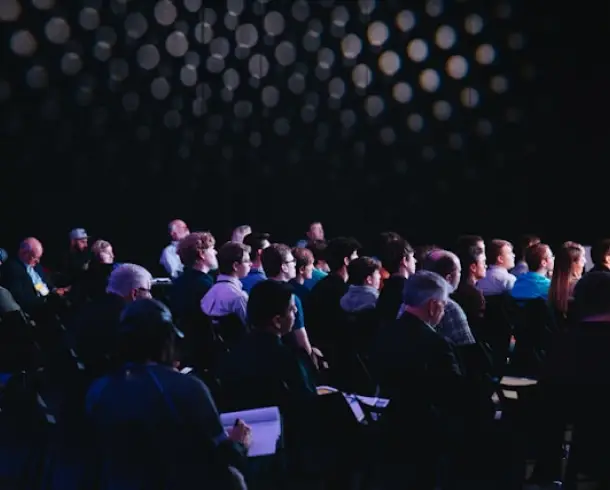 Public attentif dans une salle sombre pendant une présentation 